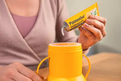 Person zeigt, wie die Salbe in den Inhalator gefüllt wird