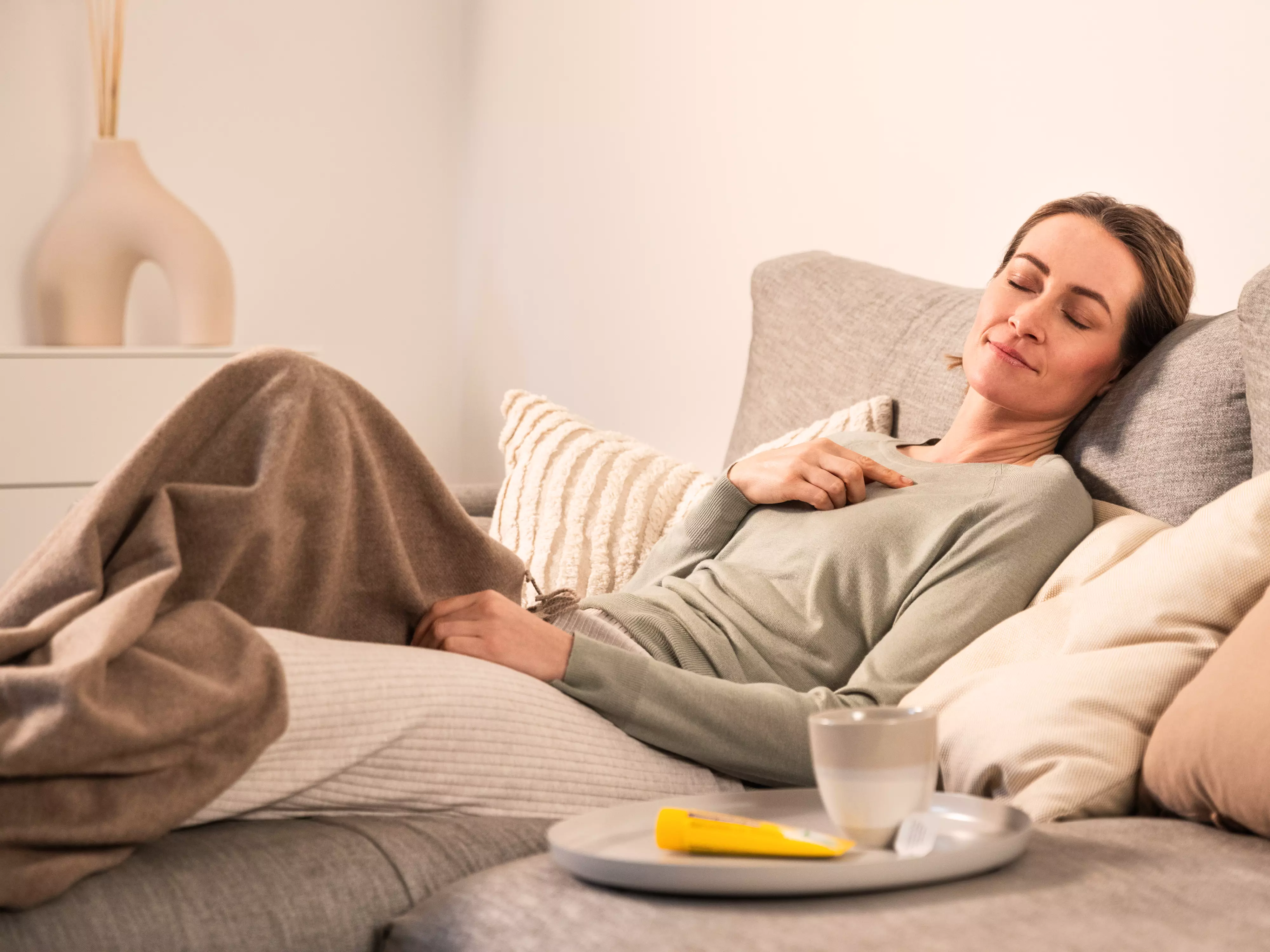 Frau liegt auf der Couch und schläft