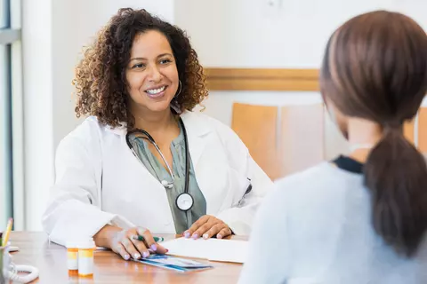 Ärtzin und eine Patientin sprechen im Behandlungzimmer