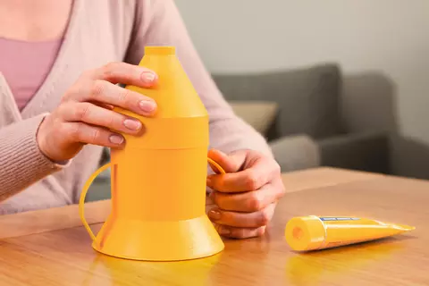 Person zeigt, wie der Aufsatz auf den Inhalator gesteckt wird
