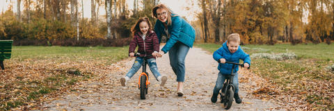 Kinder fahren Laufrad im Park