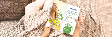Hände halten eine Broschüre von Pinimenthol